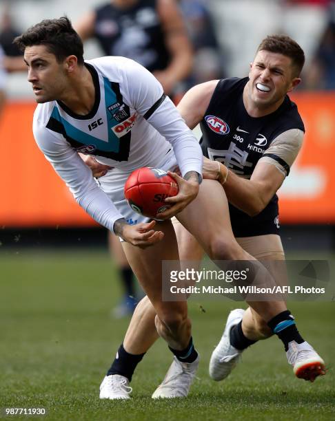 Chad Wingard of the Power is tackled by Marc Murphy of the Blues during the 2018 AFL round15 match between the Carlton Blues and the Port Adelaide...