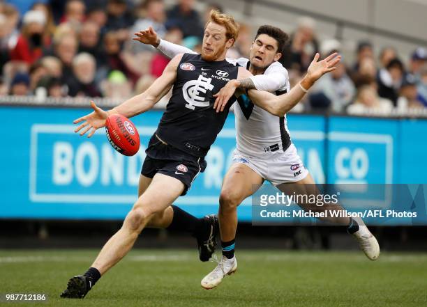 Andrew Phillips of the Blues is tackled by Chad Wingard of the Power during the 2018 AFL round15 match between the Carlton Blues and the Port...