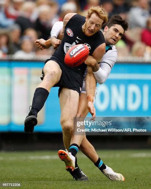 Andrew Phillips of the Blues is tackled by Chad Wingard of the Power during the 2018 AFL round15 match between the Carlton Blues and the Port...