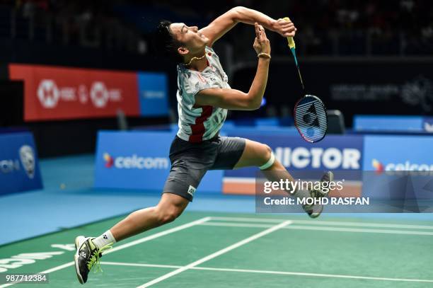 Kento Momota of Japan smashes against Srikanth Kidambi of India in their men's singles semifinal match at the Malaysia Open Badminton tournament in...