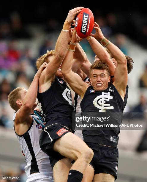 Tom Clurey of the Power, Andrew Phillips of the Blues and Patrick Cripps of the Blues compete for the ball during the 2018 AFL round15 match between...