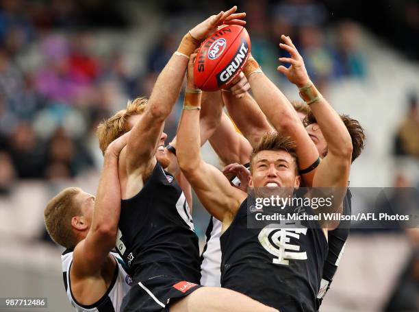 Tom Clurey of the Power, Andrew Phillips of the Blues and Patrick Cripps of the Blues compete for the ball during the 2018 AFL round15 match between...