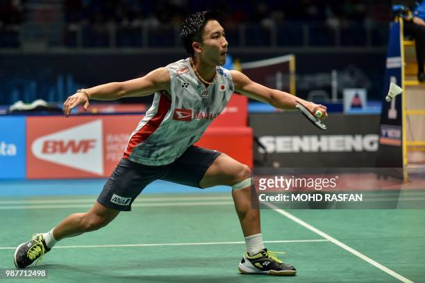 Kento Momota of Japan hits a return against Srikanth Kidambi of India in their men's singles semifinal match at the Malaysia Open Badminton...
