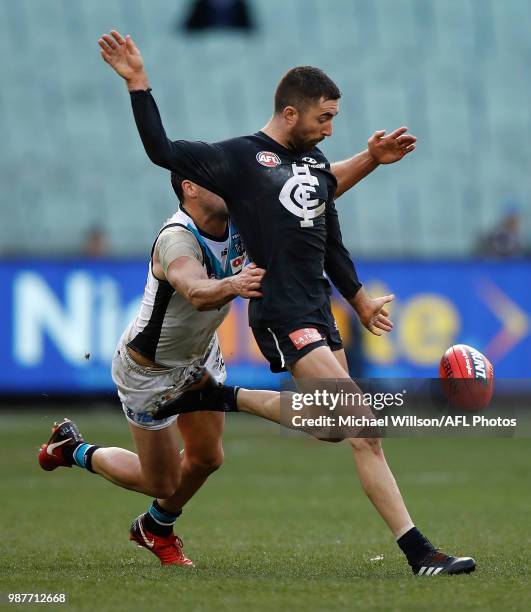 Kade Simpson of the Blues is tackled by Travis Boak of the Power during the 2018 AFL round15 match between the Carlton Blues and the Port Adelaide...