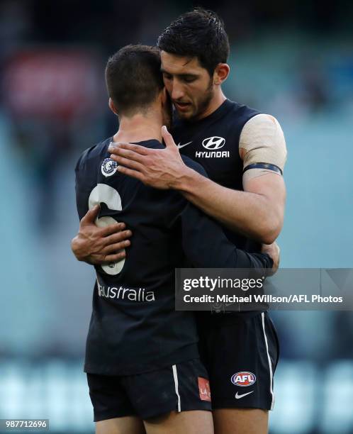 Kade Simpson of the Blues is congratulated by teammate Jacob Weitering after his 300th match during the 2018 AFL round15 match between the Carlton...