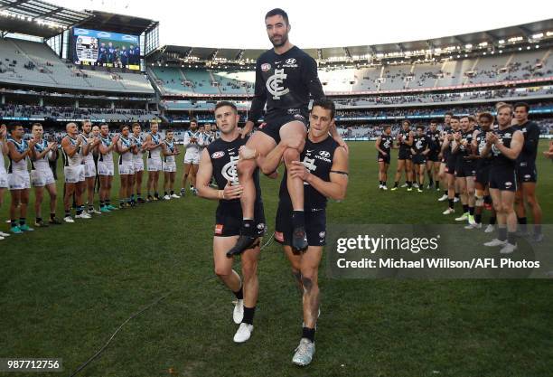 Kade Simpson of the Blues is chaired from the field after his 300th match by teammates Marc Murphy and Ed Curnow during the 2018 AFL round15 match...