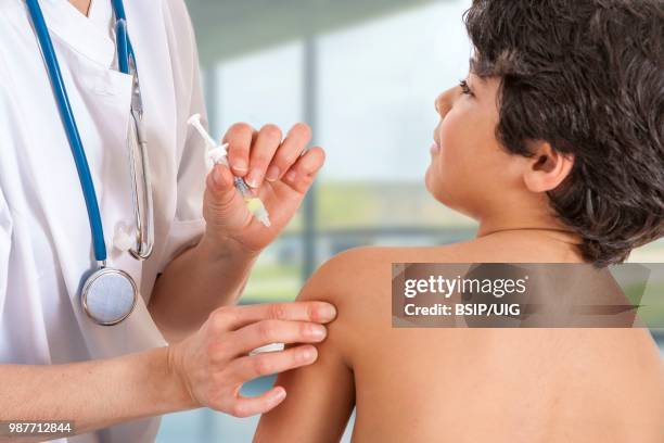 vaccinating a boy. - bsip stockfoto's en -beelden