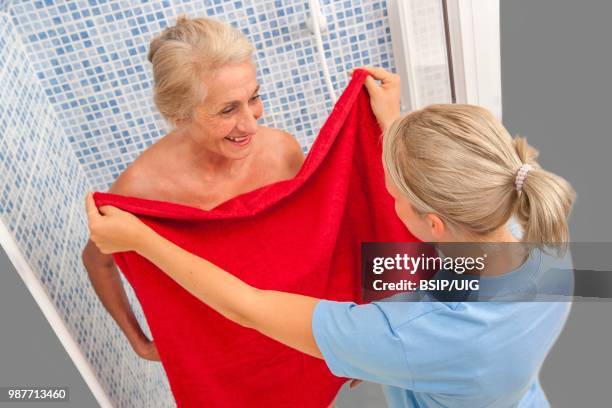 nurse helping a senior woman to wash. - bsip stock pictures, royalty-free photos & images