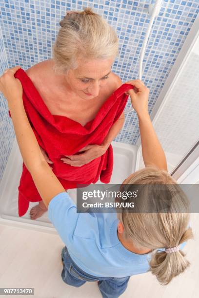 nurse helping a senior woman to wash. - bsip stock pictures, royalty-free photos & images