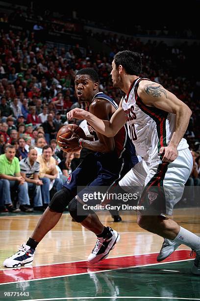 Joe Johnson of the Atlanta Hawks drives to the basket against Carlos Delfino of the Milwaukee Bucks in Game Four of the Eastern Conference...