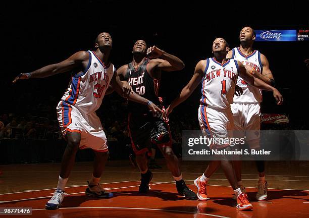 Earl Barron, Chris Duhon and Tracy McGrady of the New York Knicks box out as they look to rebound against Joel Anthony of the Miami Heat during the...