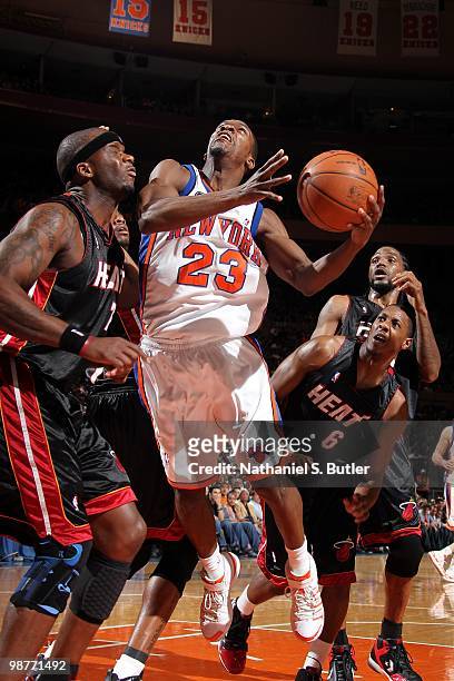 Toney Douglas of the New York Knicks goes up for a shot against Jermaine O'Neal and Mario Chalmers of the Miami Heat during the game at Madison...