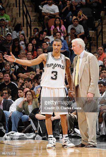 George Hill and head coach Gregg Popovich of the San Antonio Spurs talk in Game Six of the Western Conference Quarterfinals against the Dallas...