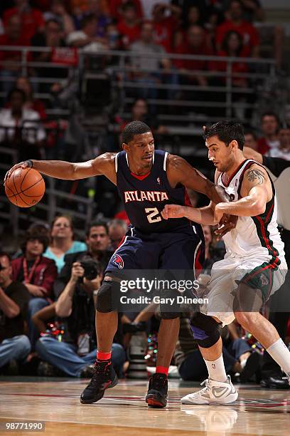 Joe Johnson of the Atlanta Hawks posts up against Carlos Delfino of the Milwaukee Bucks in Game Six of the Eastern Conference Quarterfinals during...