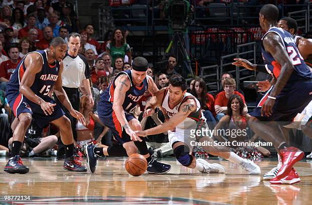 Carlos Delfino of the Milwaukee Bucks battles for a loose ball against Mike Bibby of the Atlanta Hawks in Game Six of the Eastern Conference...