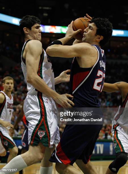Zaza Pachulia of the Atlanta Hawks is fouled by Ersan Ilyasova of the Milwaukee Bucks in Game Six of the Eastern Conference Quarterfinals during the...