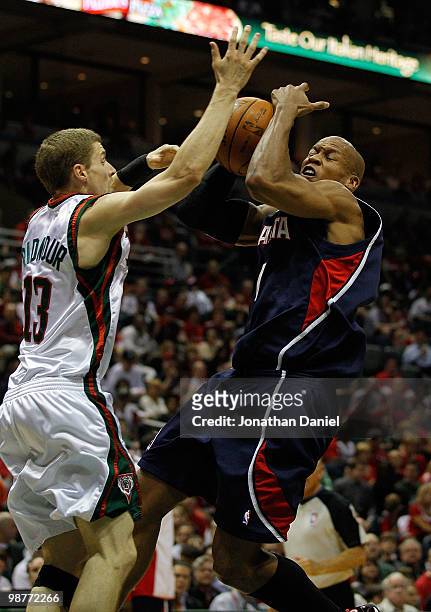 Maurice Evans of the Atlanta Hawks is fouled while shooting by Luke Ridnour of the Milwaukee Bucks in Game Six of the Eastern Conference...