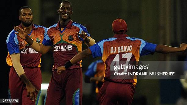 West Indies cricketers kieron Pollard and Dwayne Bravo celebrates with Darren Sammy the wicket of George Dockrell of Ireland during their ICC World...