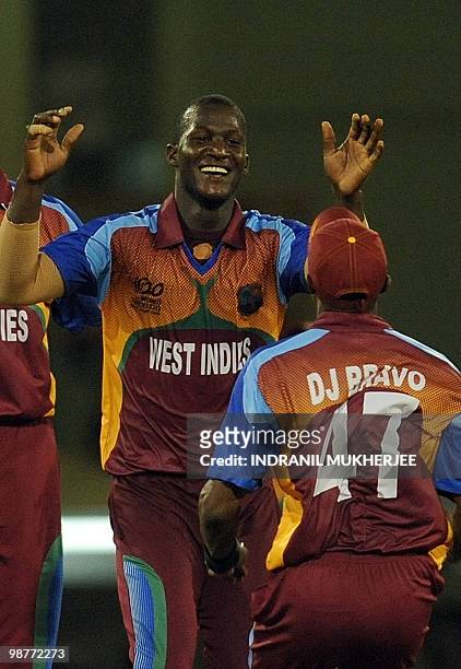 West Indies cricketers Darren Sammy and Dwayne Bravo celebrate the wicket of George Dockrell of Ireland and their victory during their ICC World...