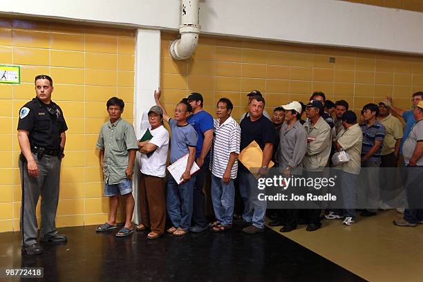 Fishermen wait in line to receive a contract from BP company representatives to use their boats to help clean up the oil spill in the Gulf of Mexico...