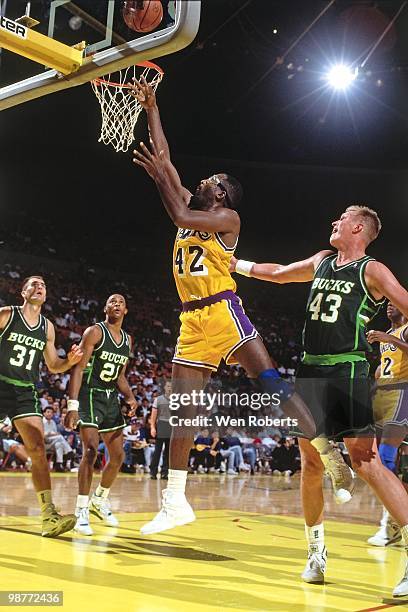 James Worthy of the Los Angeles Lakers shoots a layup against Jack Sikma of the Milwaukee Bucks during a game played circa 1988 at the Great Western...