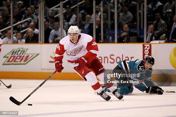 Joe Pavelski of the San Jose Sharks lies on the ice while Valtteri Filppula of the Detroit Red Wings skates away with the puck in Game One of the...