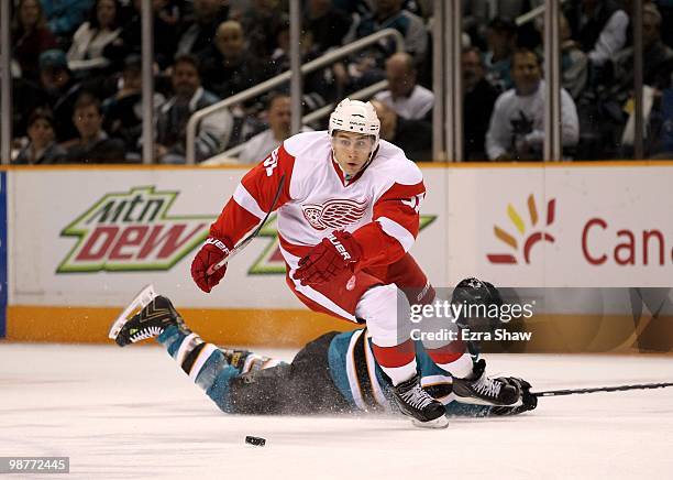 Joe Pavelski of the San Jose Sharks lies on the ice while Valtteri Filppula of the Detroit Red Wings skates away with the puck in Game One of the...