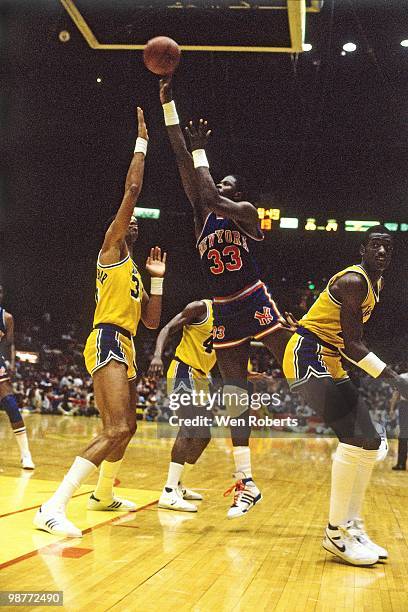 Patrick Ewing of the New York Knicks shoots a layup over Kareem Abdul-Jabbar of the Los Angeles Lakers during a game played circa 1987 at the Great...