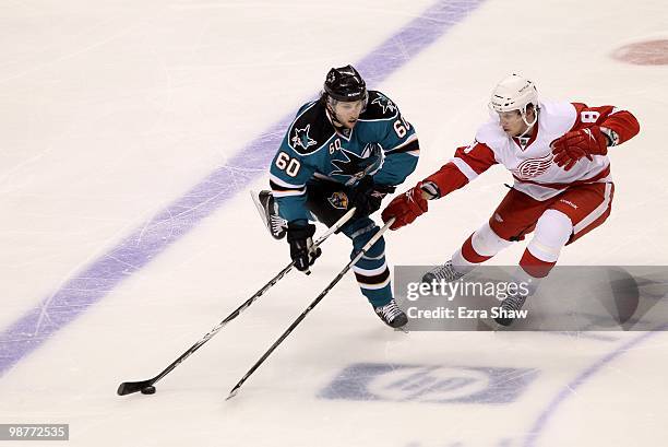 Jason Demers of the San Jose Sharks and Justin Abdelkader of the Detroit Red Wings go for the puck in Game One of the Western Conference Semifinals...