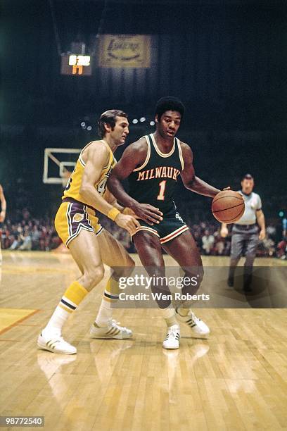 Oscar Robertson of the Milwaukee Bucks moves the ball up court against Jerry West of the Los Angeles Lakers during a game played circa 1971 at the...