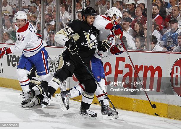 Maxime Talbot of the Pittsburgh Penguins battles for the puck between the defense of Michael Cammalleri and Travis Moen of the Montreal Canadiens in...