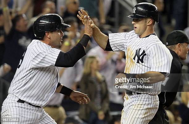 Brett Gardner and Francisco Cervelli of the New York Yankees celebrate after scoring in the seventh inning against the Chicago White Sox after a...