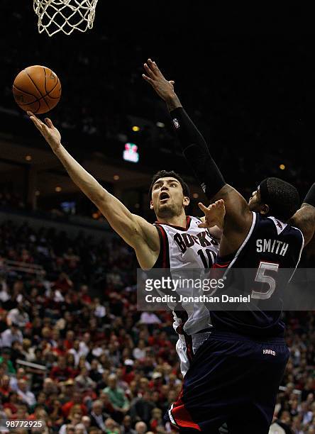 Carlos Delfino of the Milwaukee Bucks puts up a shot around Josh Smith of the Atlanta Hawks in Game Six of the Eastern Conference Quarterfinals...