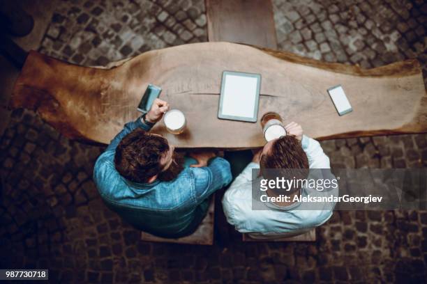 male friends enjoying beer time at bar and watching videos on tablet - human body part videos stock pictures, royalty-free photos & images