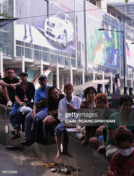 Thai Red Shirt anti-government protesters sit listening to speeches next to a shopping center during a rally in the financial central district of...