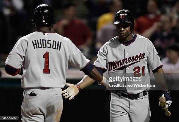 Delmon Young congratulates teammate Orlando Hudson of the Minnesota Twins after scoring against the Cleveland Indians during the game on April 30,...