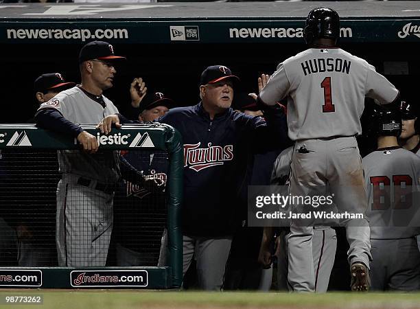 Orlando Hudson of the Minnesota Twins is congratulated by manager Ron Gardenhire after scoring against the Cleveland Indians during the game on April...