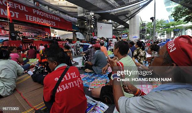 Thai Red Shirt anti-government protesters clap as they attend a rally held inside their fortified camp in the financial central district of Silom in...