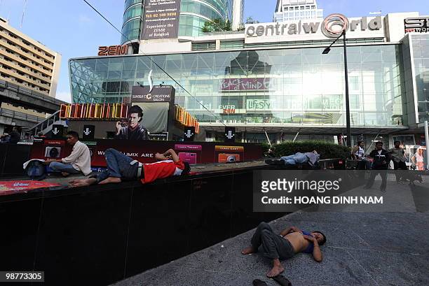 Thai Red Shirt anti-government protesters sleep on the ground next to a shopping mail inside their fortified camp in the financial central district...