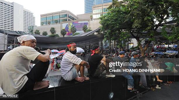 Thai Red Shirt anti-government protesters sit listening to speeches during a rally held next near a shopping mall inside their fortified camp in the...