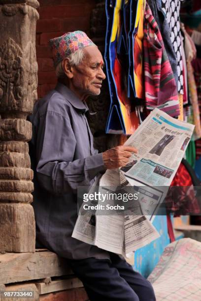 nepalesische senior woman überprüfen die nepal-news - thamel stock-fotos und bilder