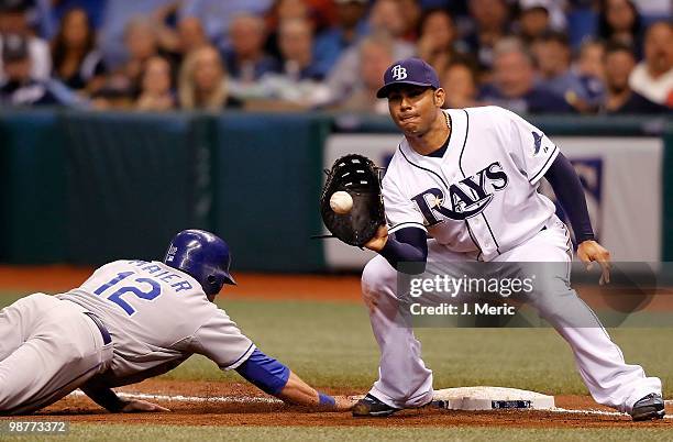 First baseman Carlos Pena of the Tampa Bay Rays takes the throw at first as Mitch Maier of the Kansas City Royals gets back safely during the game at...