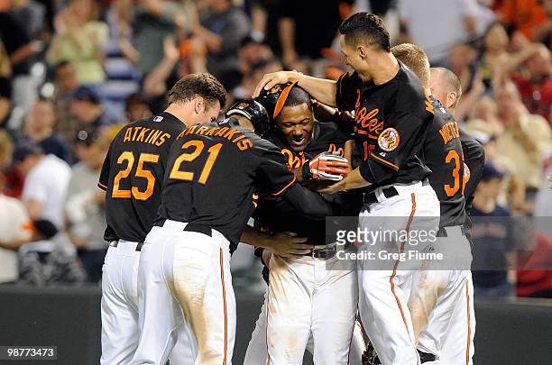 Miguel Tejada of the Baltimore Orioles is mobbed by teammates after driving in the game winning run in the tenth inning against the Boston Red Sox at...