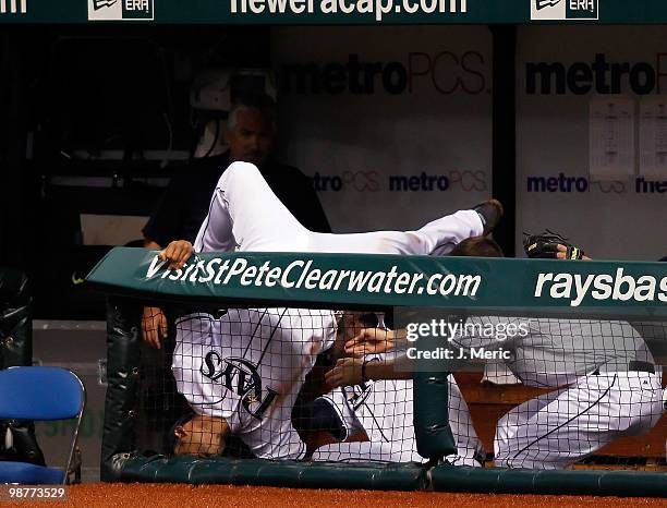 First baseman Carlos Pena of the Tampa Bay Rays falls into the dugout after catching a foul ball against the Kansas City Royals during the game at...