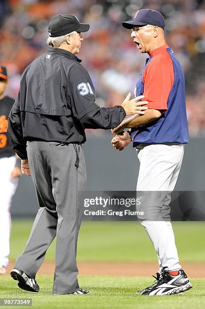 Manager Terry Francona of the Boston Red Sox argues with umpire Mike Reilly after a runners interference call in the seventh inning against the...
