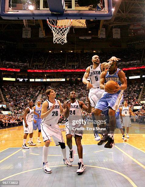 Joey Graham of the Denver Nuggets grabs a rebound while defended by Carlos Boozer, Paul Millsap and Kyle Korver of the Utah Jazz during Game Six of...