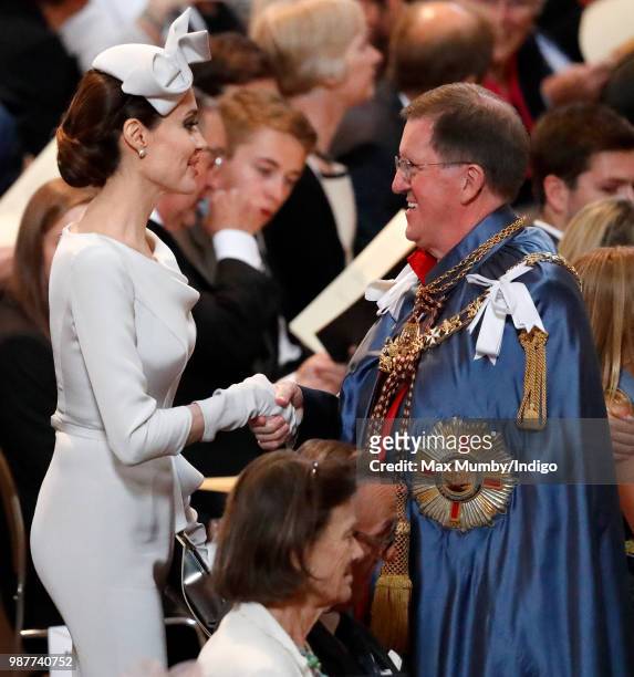 Angelina Jolie, an Honorary Dame Commander of The Most Distinguished Order of Saint Michael and Saint George, greets Lord George Robertson as she...