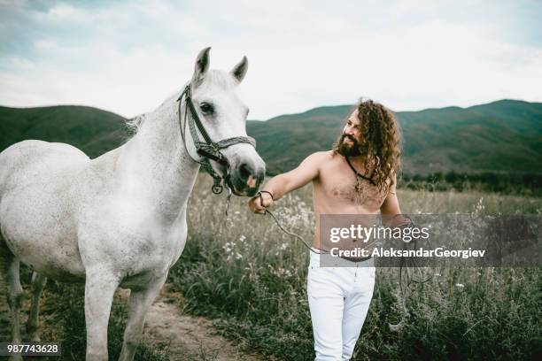 männliches pferdetrainer führt sein pferd durchgangsgleis wiese - beautiful male feet stock-fotos und bilder