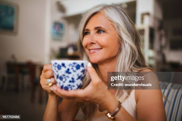 portrait of beautiful mature woman drinking tea at coffee shop - beautiful woman gray hair stock pictures, royalty-free photos & images