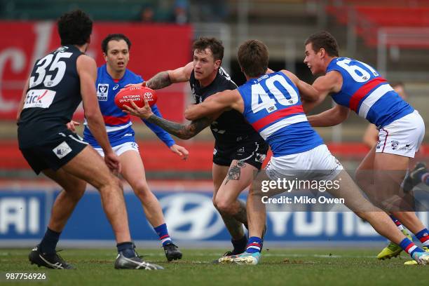 Cameron O'Shea of the Blues is tackled during the round 13 VFL match between the Northern Blues and the Footscray Bulldogs at Ikon Park on June 30,...